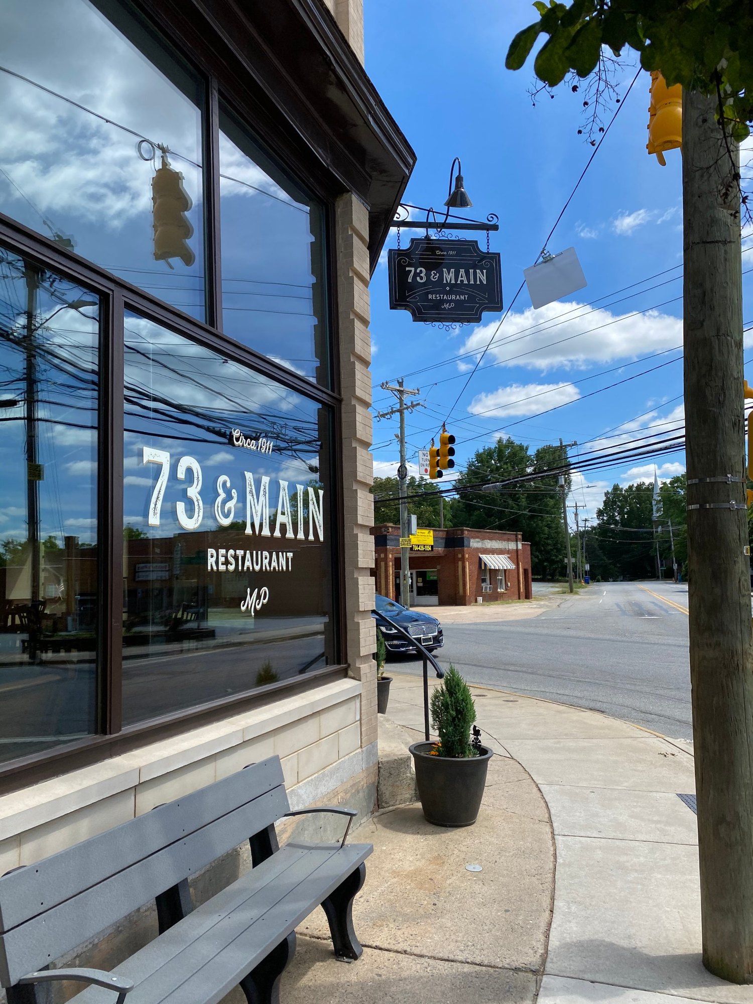 The restaurant's corner storefront with the logo on the window and a hanging blade sign
