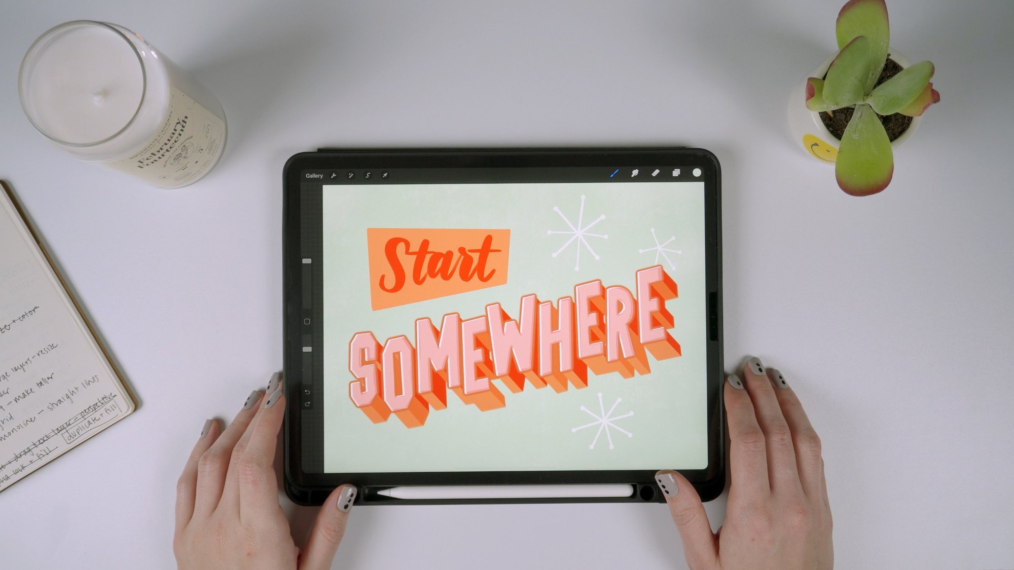 An iPad in Procreate showing Start Somewhere lettering: a red brush script Start on an orange panel above pink dimensional block caps with orange drop shades, on a mint background with starbursts